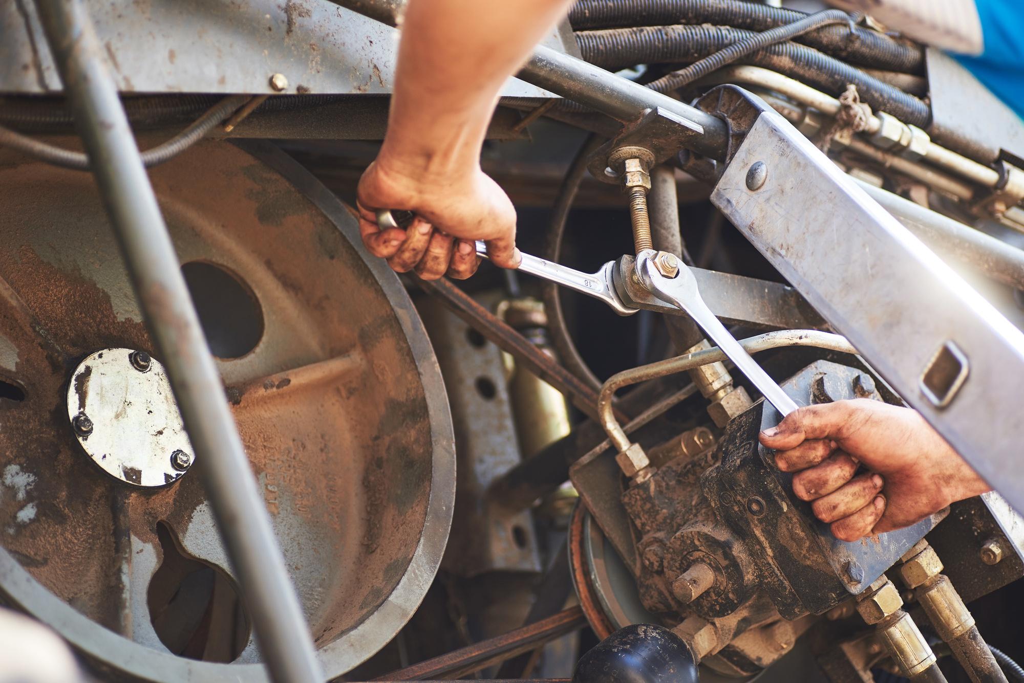 Mechanics using wrenches on industrial machinery